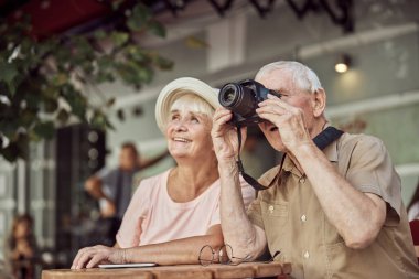 Dijital kamerasının lensinden bakan bir adam