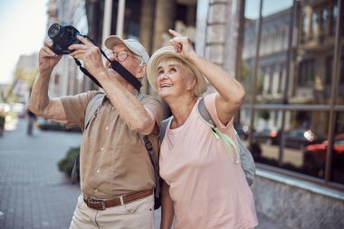 Erkek emekli dijital kamerasıyla fotoğraf çekiyor.