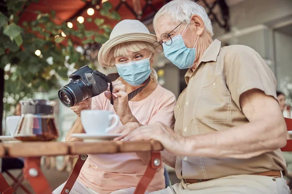 Konzentrierter Mann sitzt neben einer Frau mit einem optischen Gerät — Stockfoto