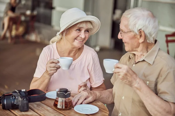 Příjemný starší pár sedí v kavárně — Stock fotografie