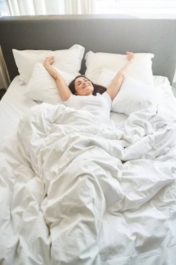 Kadın sabah uyandıktan sonra kendini geriyor.