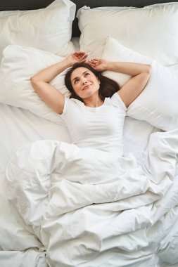 Koyu saçlı bayan tavana bakıyor.