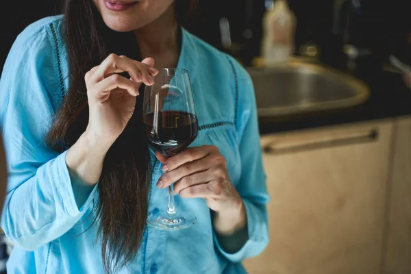 Elinde şarap kadehi tutan siyah saçlı kadın.