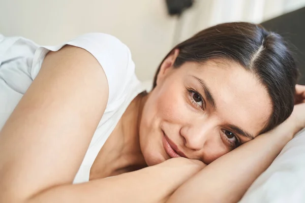 Mujer joven y serena sonriendo después de despertar — Foto de Stock