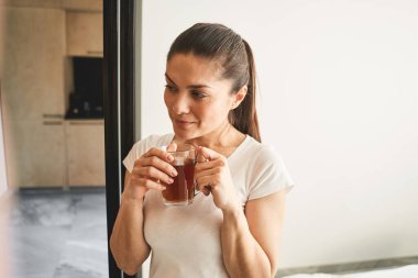 Düşünceli güzel bayan duvarın önünde duruyor.