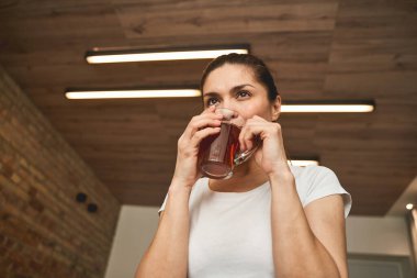 Hayalperest kadın, elinde meşrubatla Uzağa bakıyor