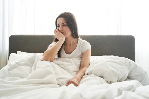 Tristă femeie grijuliu stând într-un dormitor — Fotografie, imagine de stoc