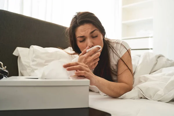 Mujer enferma sonándose la nariz con los ojos cerrados — Foto de Stock