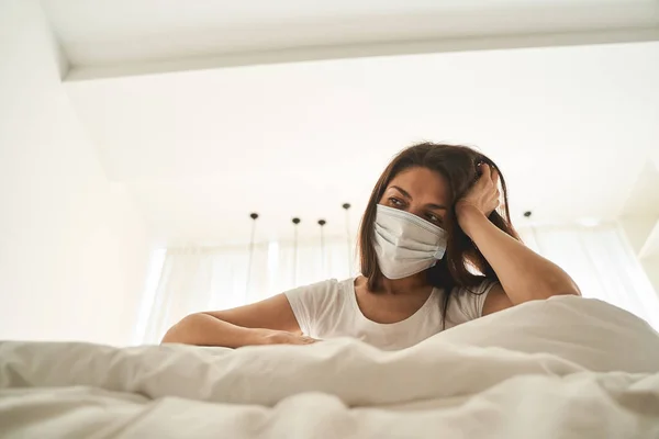 Nachdenkliche junge Frau sitzt in Quarantäne — Stockfoto