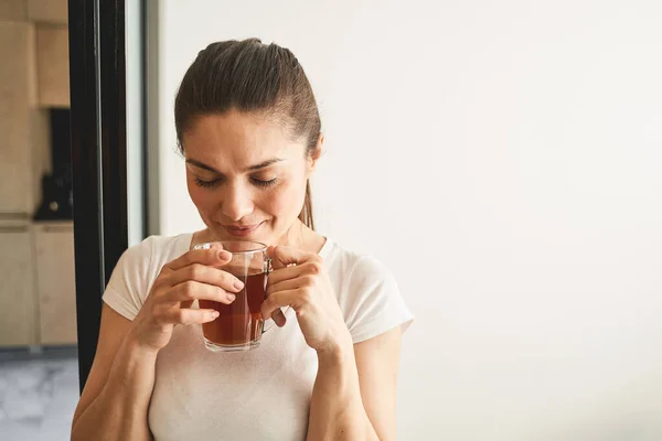 Женщина наслаждается травяным чаем с закрытыми глазами — стоковое фото