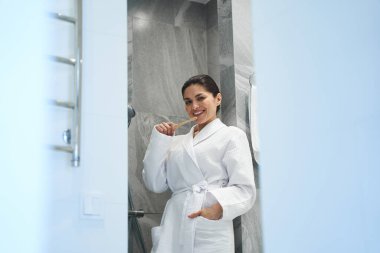 Çekici koyu saçlı bayan ağız temizliğini koruyor.