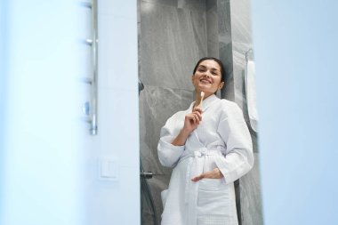 Tahta diş fırçasıyla gülümseyen hayalperest kadın.