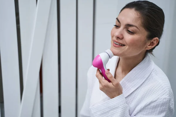 Lächelnde dunkelhaarige Frau bei einer Schönheitsoperation — Stockfoto