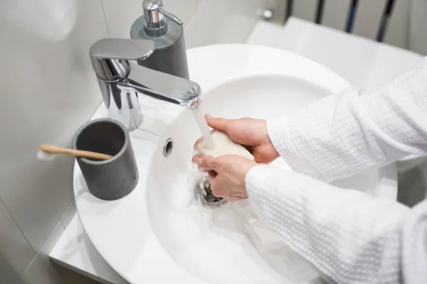 Nainen kylpytakissa pesemässä käsiään. — kuvapankkivalokuva