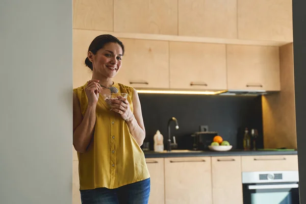 Sonriente joven mujer caucásica comiendo avena gachas — Foto de Stock