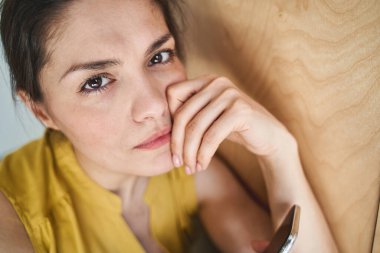 Alçak gönüllü bir kadın elinde bir alet tutuyor.