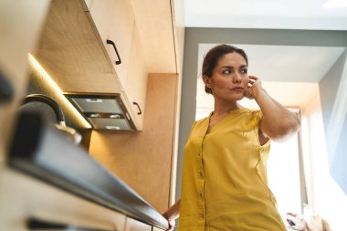 Koyu saçlı, üzgün bakışlı güzel bir bayan.