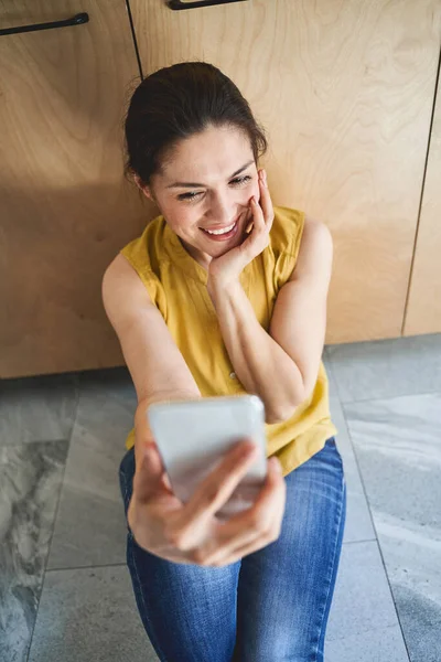 笑顔女性ポーズのために彼女のスマートフォンカメラ — ストック写真