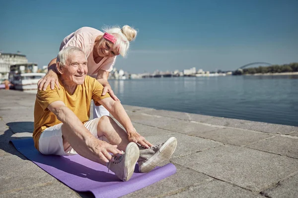 Satisfait pensionné masculin exerçant sur le tapis — Photo