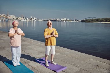 Emekliler dışarıda dua ederken meditasyon yapıyorlar.