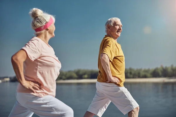 Gray-headed woman looking at a man during the workout — Stock Photo, Image