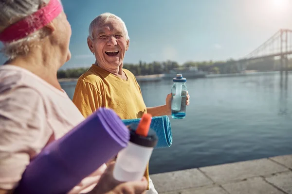 Gray-headed sporty lady gazing at a laughing man — Stock Photo, Image