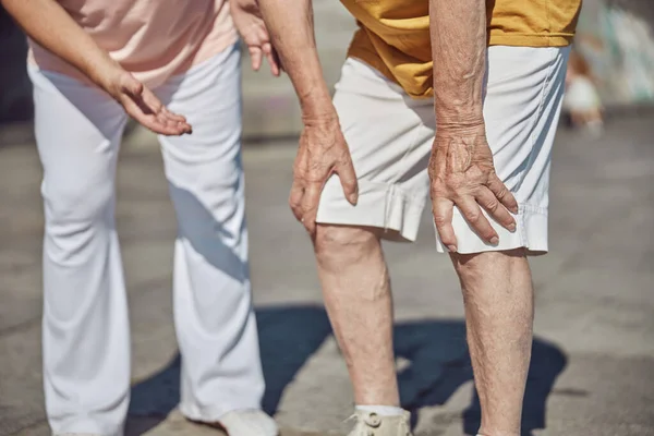 Senior man vidrör sina knän med händerna — Stockfoto