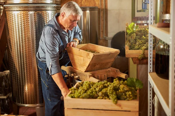 Invecchiamento viticoltore essere occupato presso la sua cantina — Foto Stock