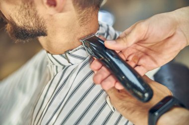 Bir ziyaretçinin saçını kesen çalışkan bir kuaför.