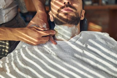 Boynuna tıraş kremi bulaşmış genç bir adam.