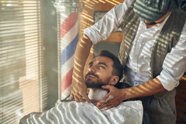 Bir berber dükkanının sakin müşterisi tıraş oluyor.