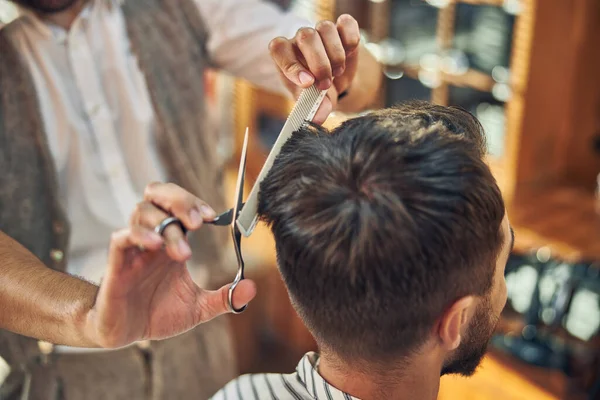 Wykwalifikowany stylista fryzjerski obcinający włosy odwiedzającemu — Zdjęcie stockowe