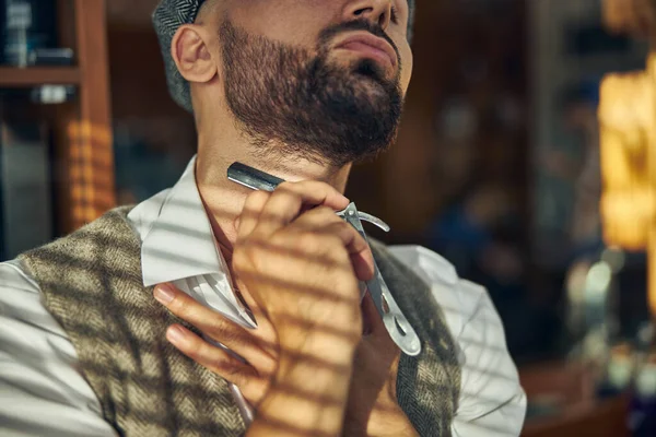 Бородатий волосся-стиліст, використовуючи пряму бритву для гоління шиї — стокове фото