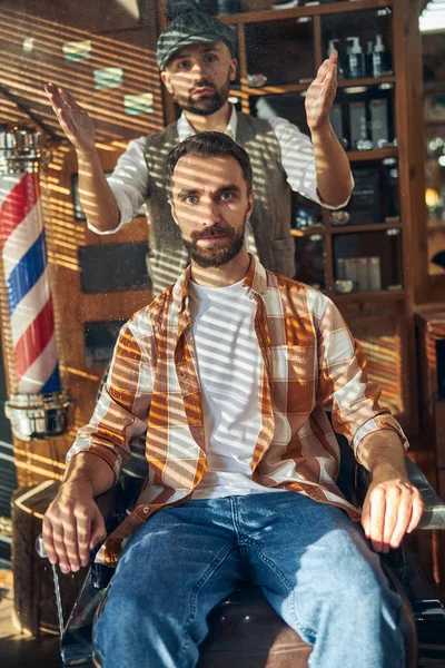 Stijlvolle kapper en hipster client poseren bij een kapperszaak — Stockfoto