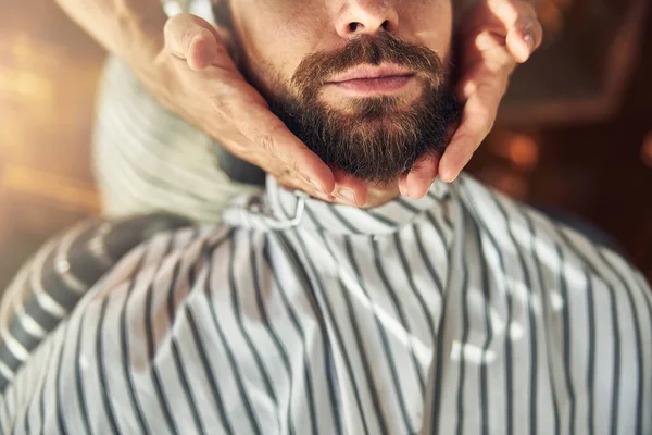 Joven cubierto de paño de peluquero con la barba arreglada — Foto de Stock