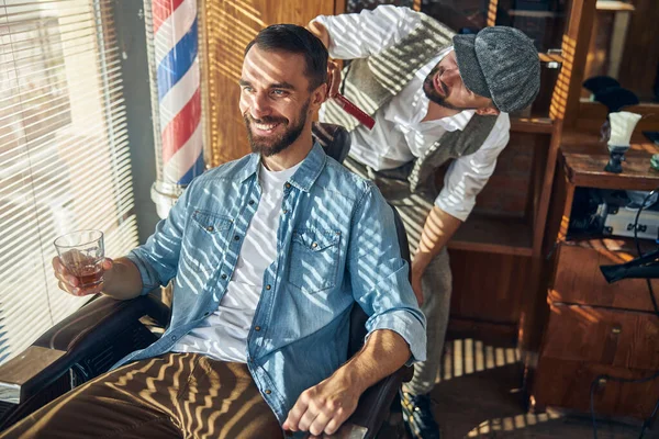 Friseurkunde genießt seinen Termin mit einem Glas Alkohol — Stockfoto