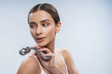 Metal silindiri elinde tutan zarif bir bayan.