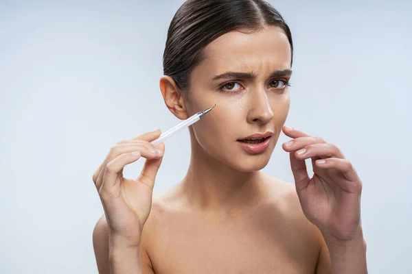 Mulher bonita sentindo-se confusa ao receber injeção facial — Fotografia de Stock