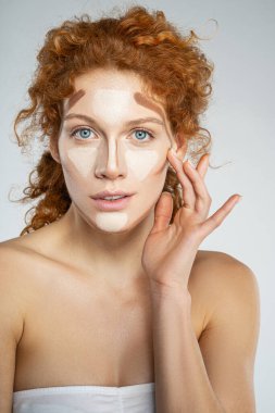 Genç ve güzel bir kadın stüdyoda makyaj yapıyor.