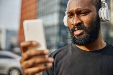 Elinde alet olan konsantre bir insan müzik dinliyor.