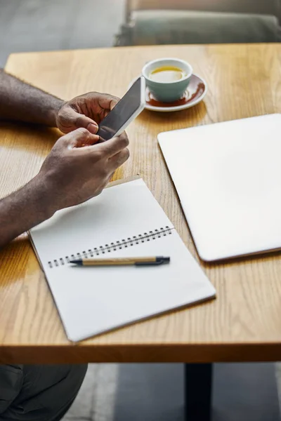 Persona usando su aparato moderno en la mesa de la cafetería —  Fotos de Stock