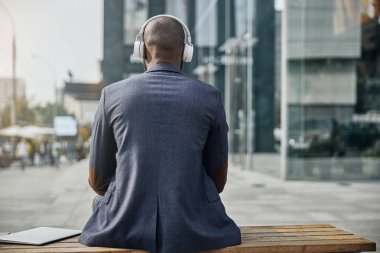 Bankta oturan genç adamın silueti.