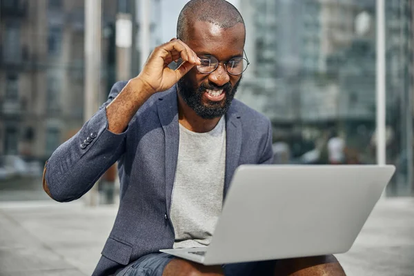 Primer plano del hombre complacido que mirando su gadget —  Fotos de Stock