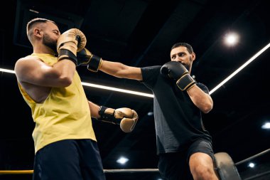 Gülen boksör ortağının darbesini savuşturuyor.