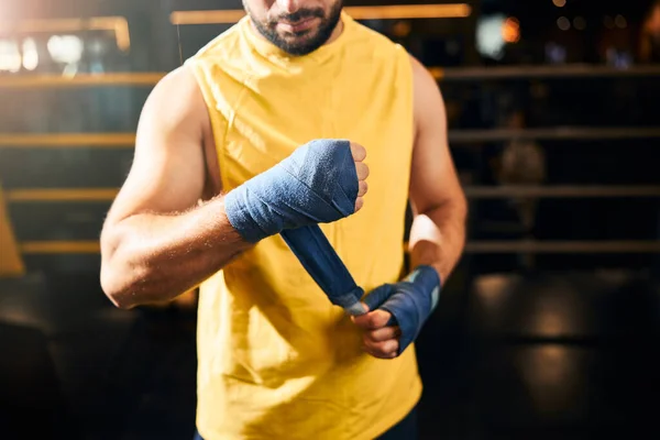 Atletisk man som lindar in armen i boxningslindor — Stockfoto