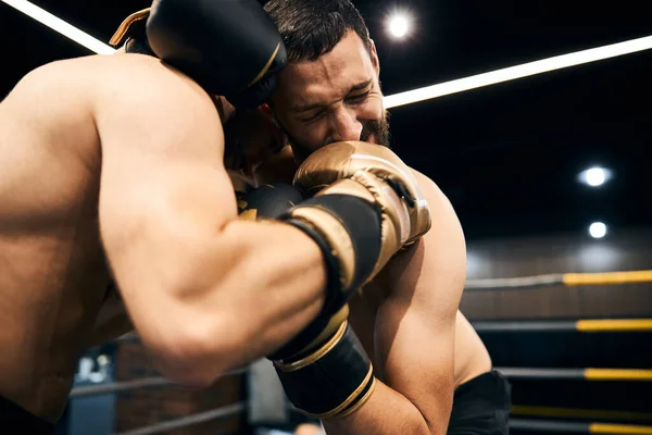 Boxeador siendo golpeado en la cara mientras sostiene a su oponente — Foto de Stock