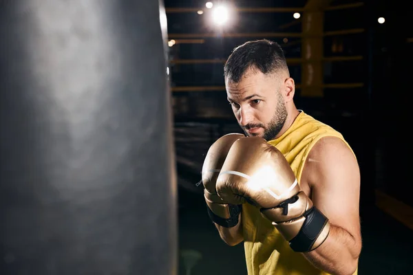 Boxer is training with heavy punch bag — Stock Photo, Image