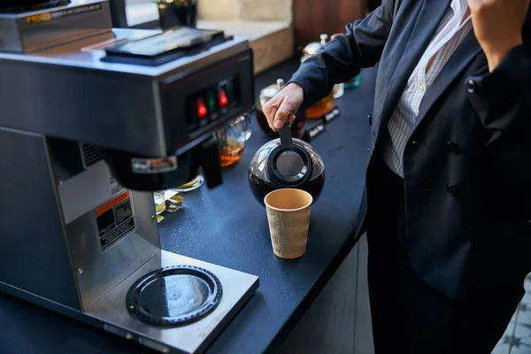 Nahaufnahme einer Frau, die sich Kaffee einschenkt — Stockfoto