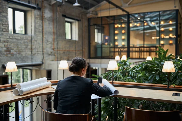 Diseñador atento trabajando con bocetos en oficina flexible — Foto de Stock