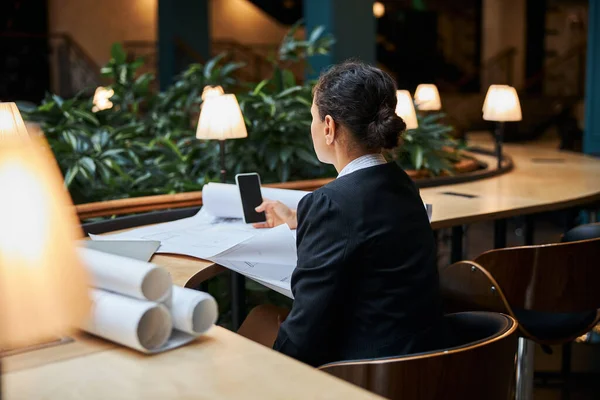 Koncentrerad brunett kvinna tittar på sin telefon — Stockfoto